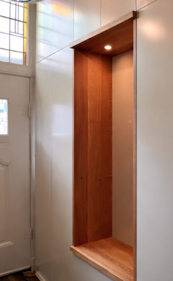 Garderobe kast met houten nis met verlichting.